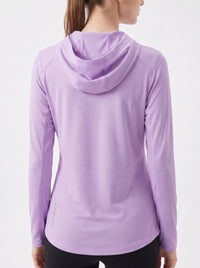 A woman wearing a light purple long-sleeve athletic hooded top, shown from the back against a plain white studio background.